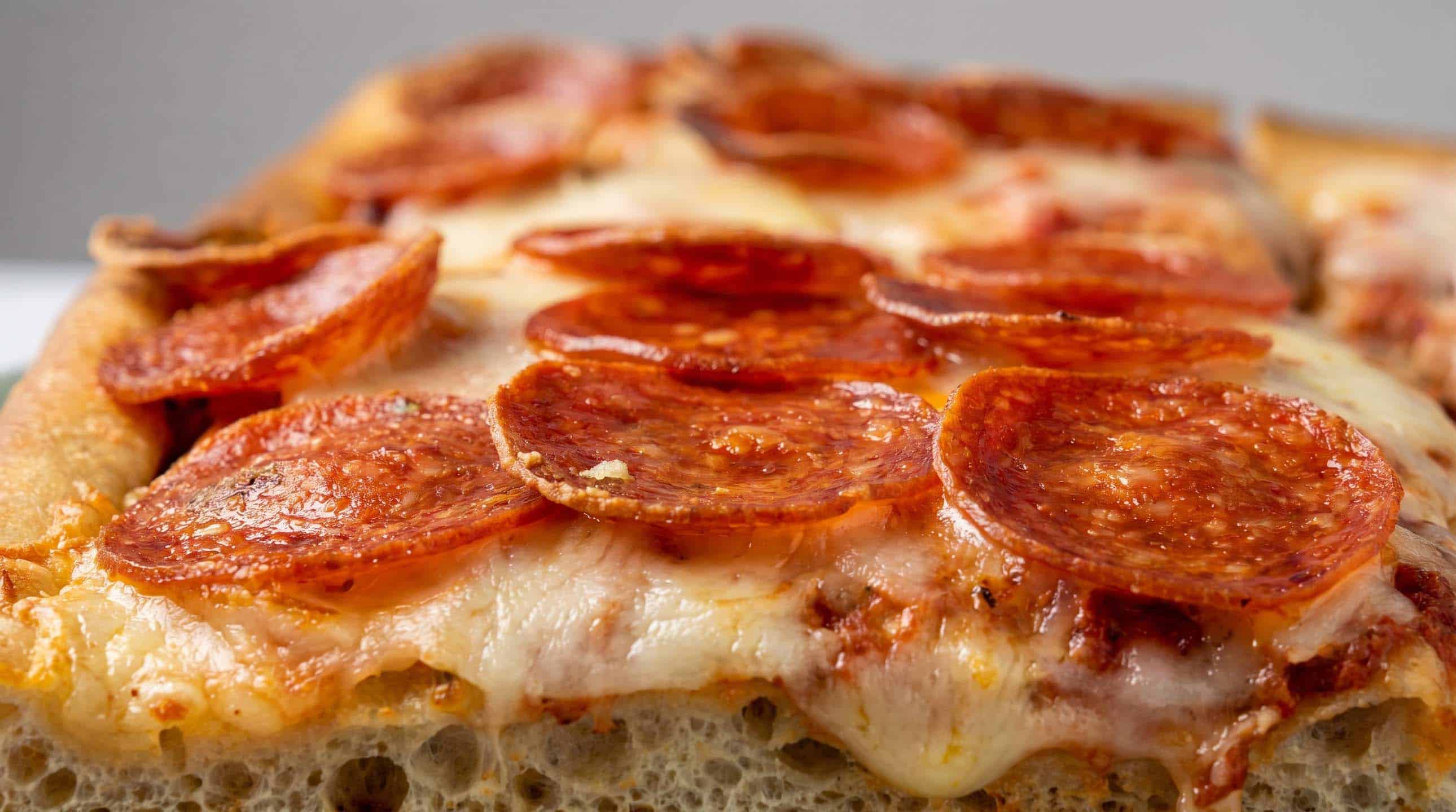 Close-up of a pepperoni pizza slice with melted cheese