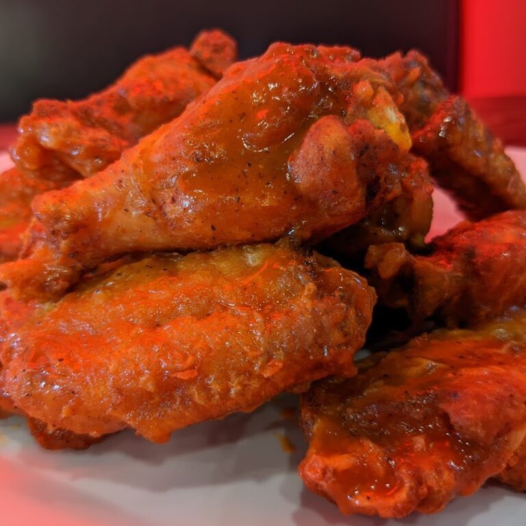 A plate of fried chicken wings on a table.